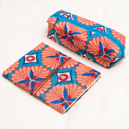 Hand printed orange cotton travel pouch styled with everyday essentials"