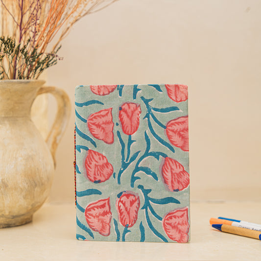Notebook with floral pattern hand block printed on cotton , placed on a neutral background