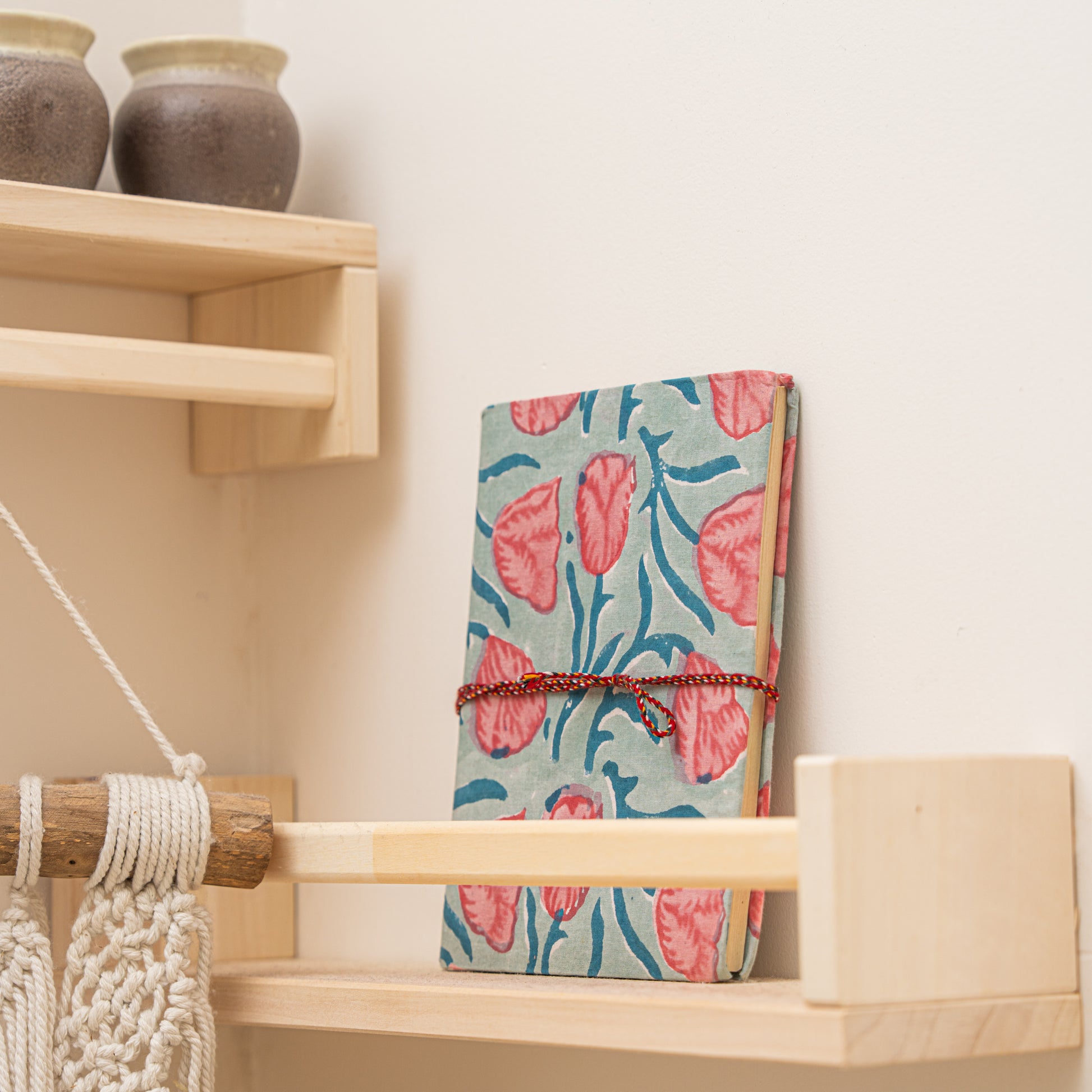 hand block printed pattern  journal placed on a wooden shelf with decorative items