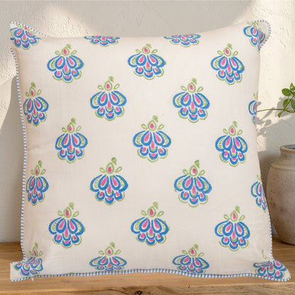 Decorative hand block printed linen pillow with colorful pattern in natural dyes placed on a wooden surface