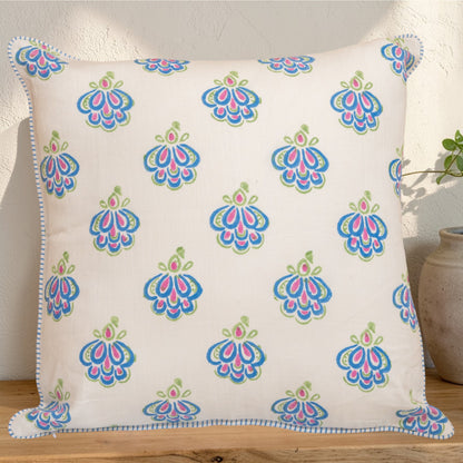 Decorative hand block printed linen pillow with colorful pattern placed on a wooden surface
