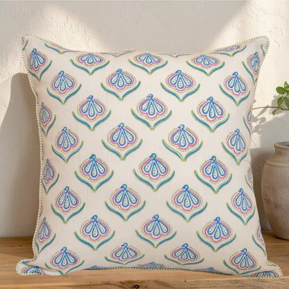 Hand block printed linen pillow cover with delicate bird print in soft blue, green and pink  natural dyes, placed on a wooden suraface.