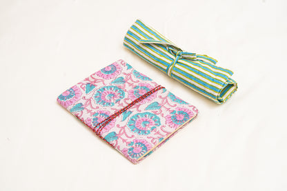 Pink and blue hand block printed fabric journal  with floral pattern and green striped cotton hand block printed  roll-up organizer  on a white background