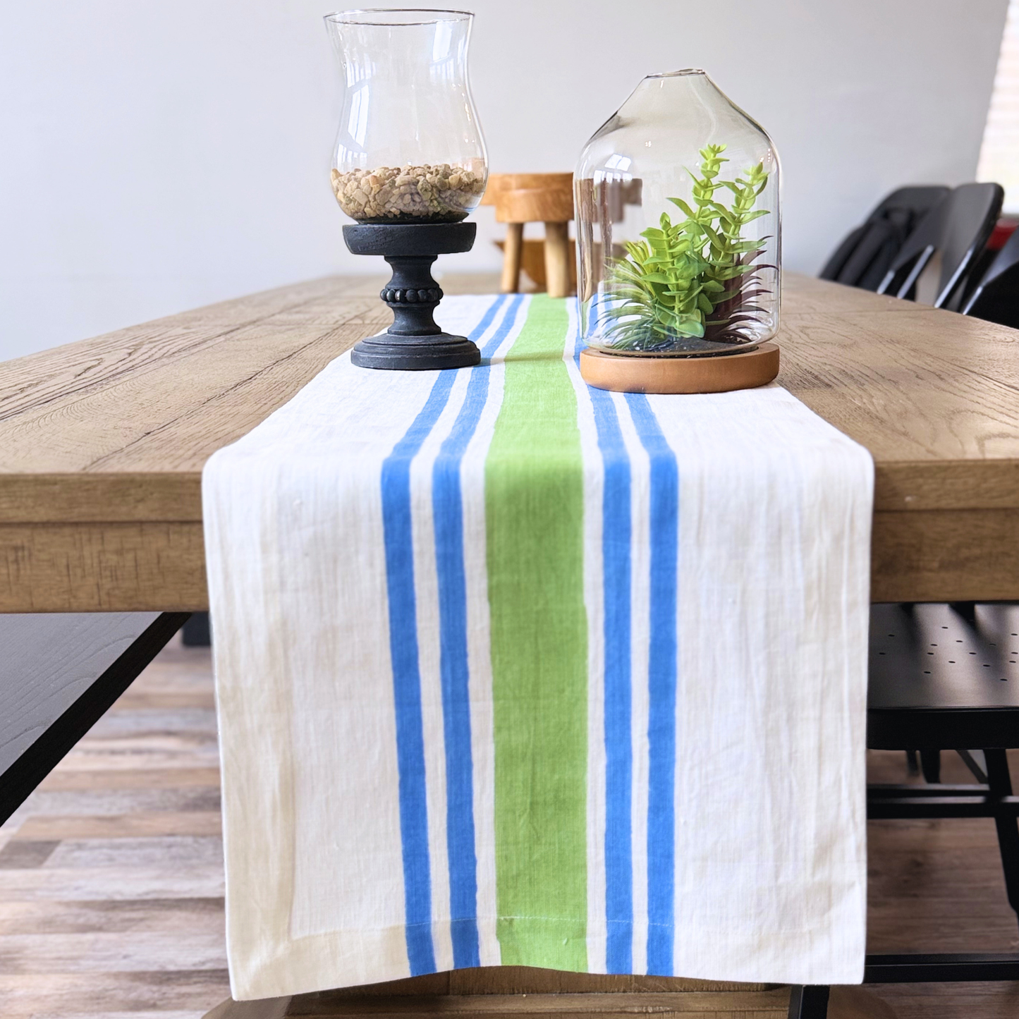 Blue and green Striped hand blocked linen table runner on a wooden table with decorative items