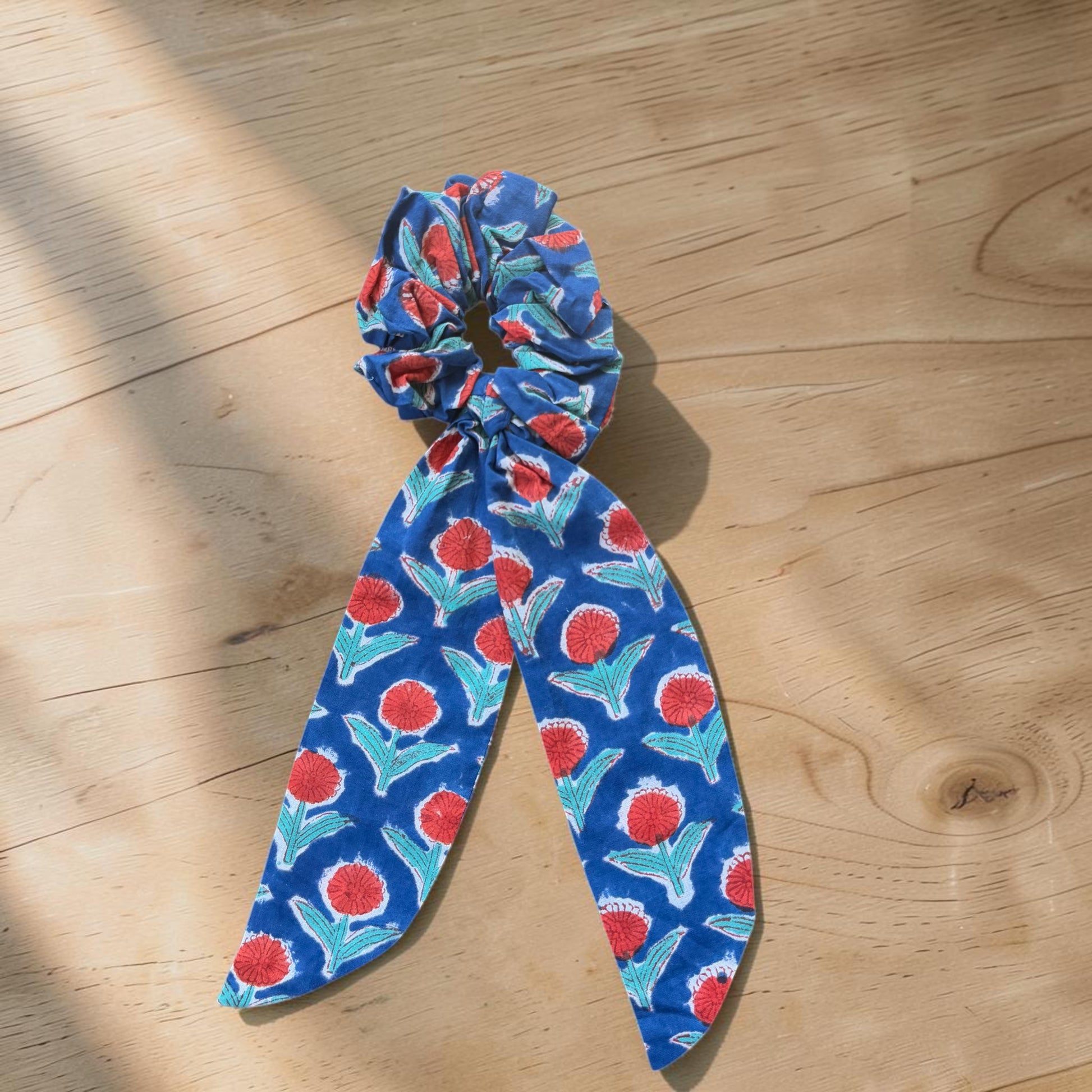 Cotton Hand Block Printed Blue scrunchie with red and green floral pattern on a wooden surface