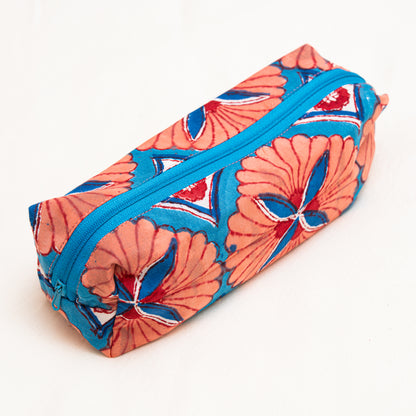 Hand block printed cotton travel pouch in orange floral pattern laid flat on a neutral surface